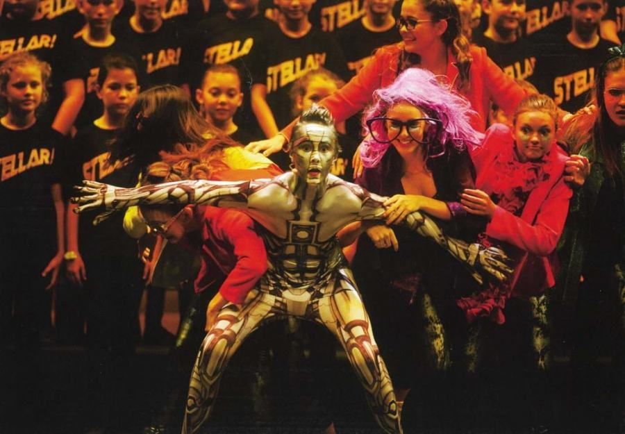 A group of people are standing in front of a wall that says stellar