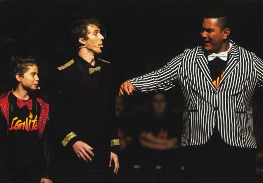 A man in a striped jacket is standing next to two other men