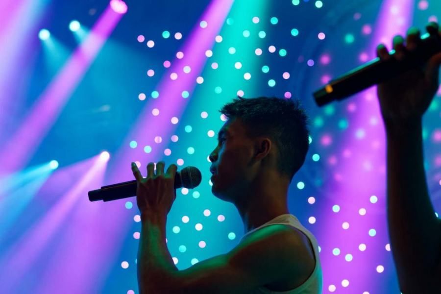 A man is singing into a microphone on a stage.
