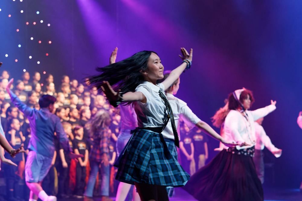 A group of young people are dancing on a stage.