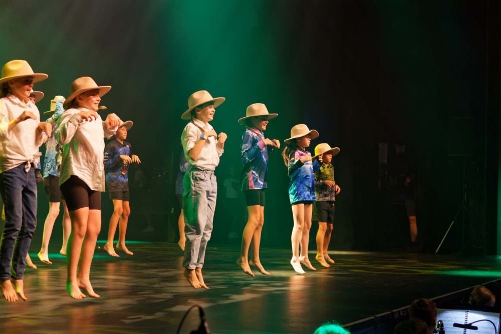 A group of children are dancing on a stage.