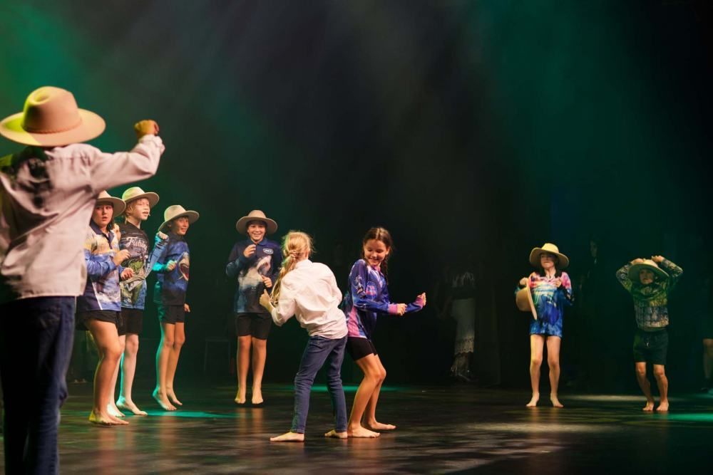 A group of children are dancing on a stage.