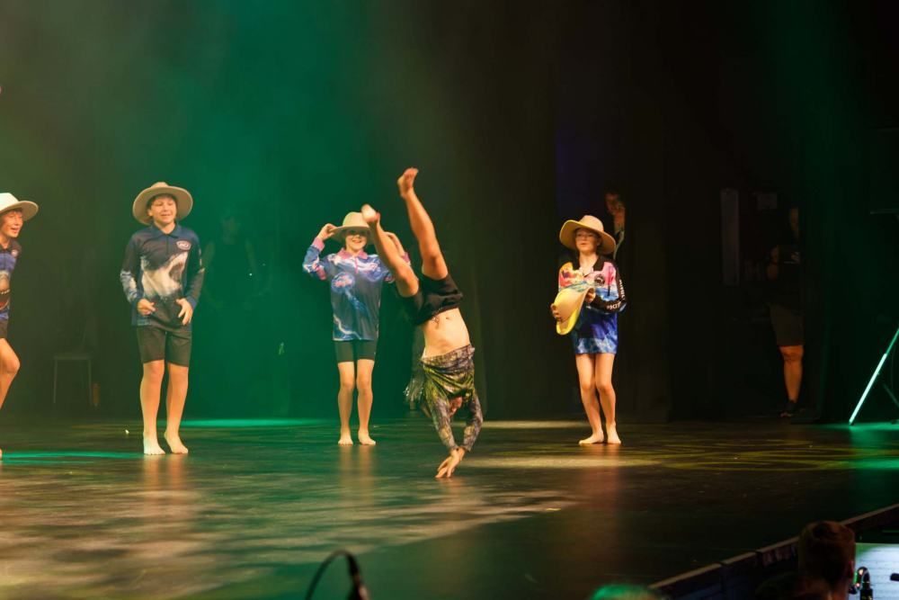 A group of children are performing a dance on a stage.
