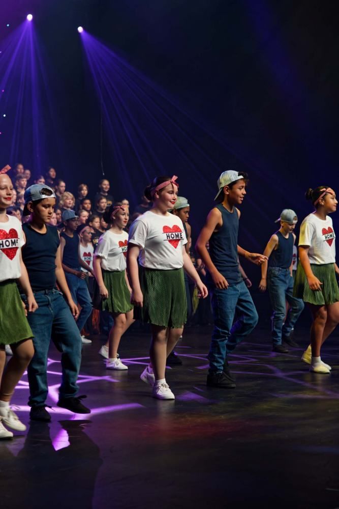 A group of young people are dancing on a stage.