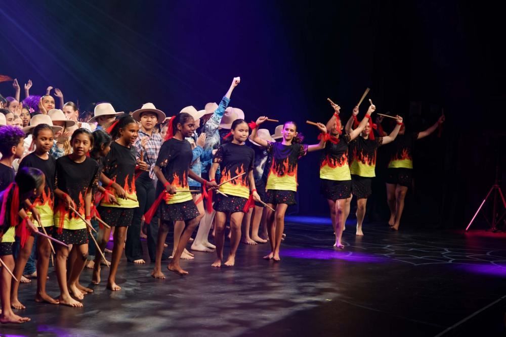 A group of children are dancing on a stage.