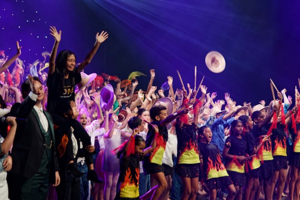 A large group of people are dancing on a stage.