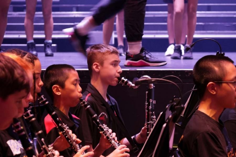 A group of people playing clarinets on a stage