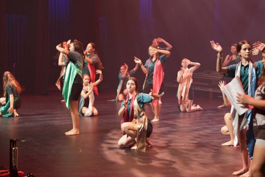 A group of young people are dancing on a stage.