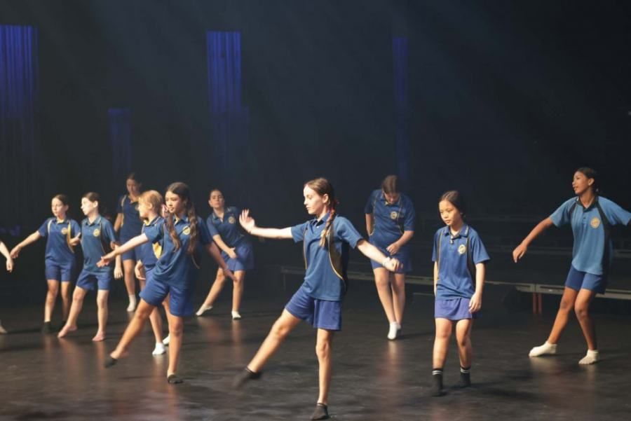 A group of children are dancing on a stage.