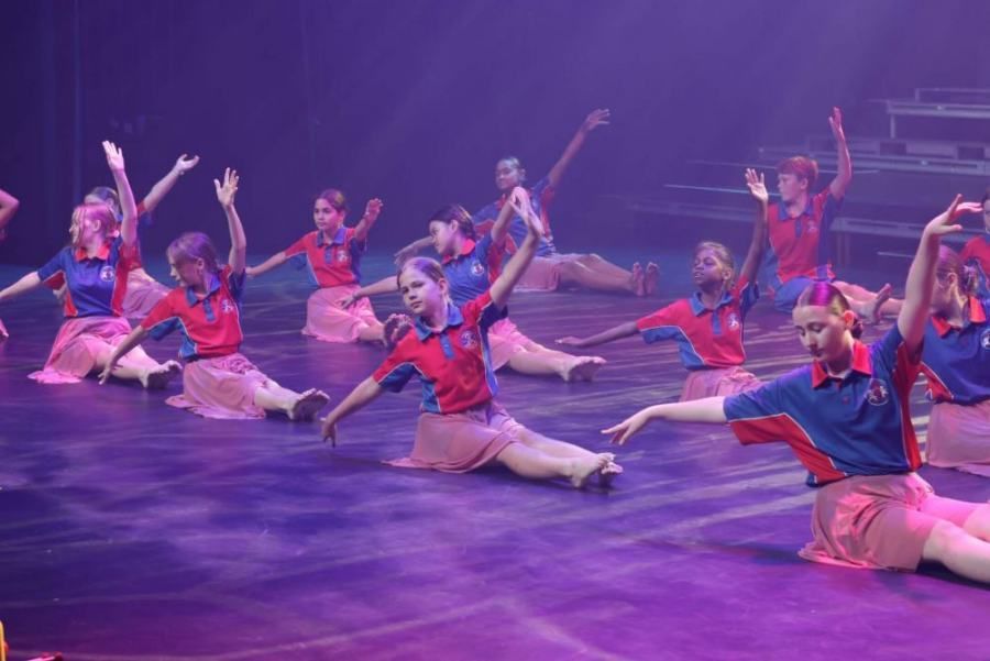 A group of young girls are doing a dance on a stage.