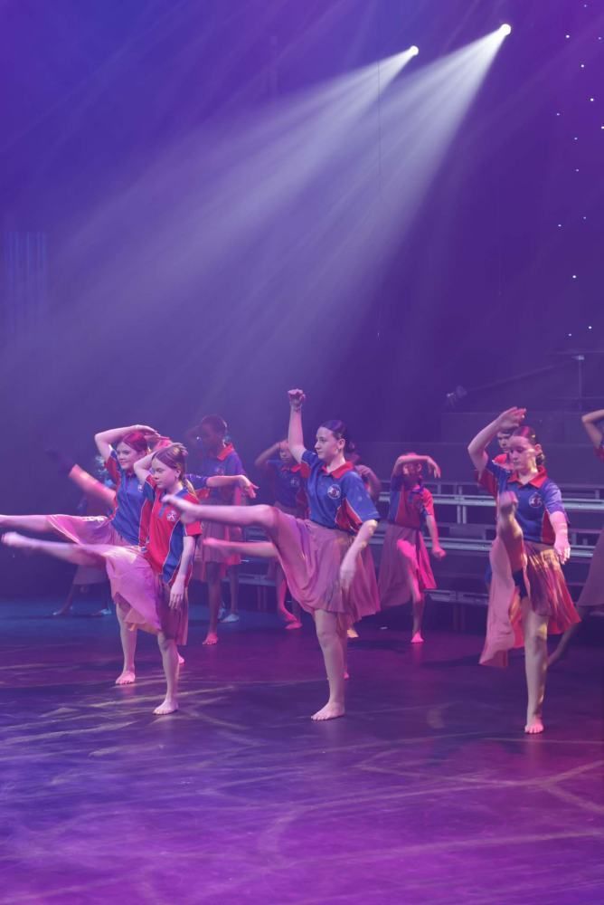 A group of young girls are dancing on a stage.
