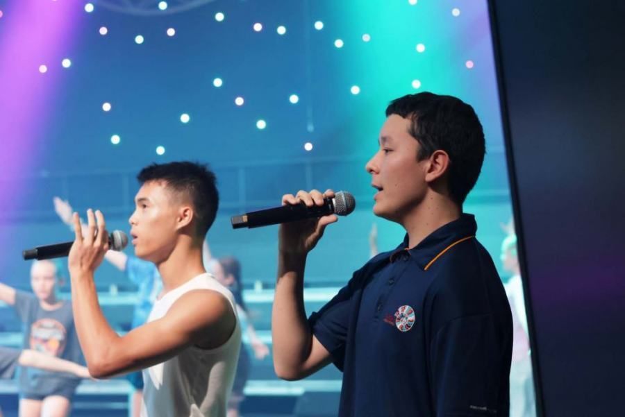 Two boys singing into microphones on a stage