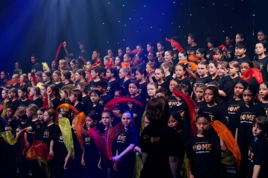 A large group of children are wearing shirts that say home