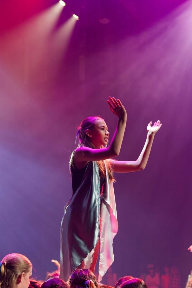 A woman is dancing on a stage in front of a crowd of people.