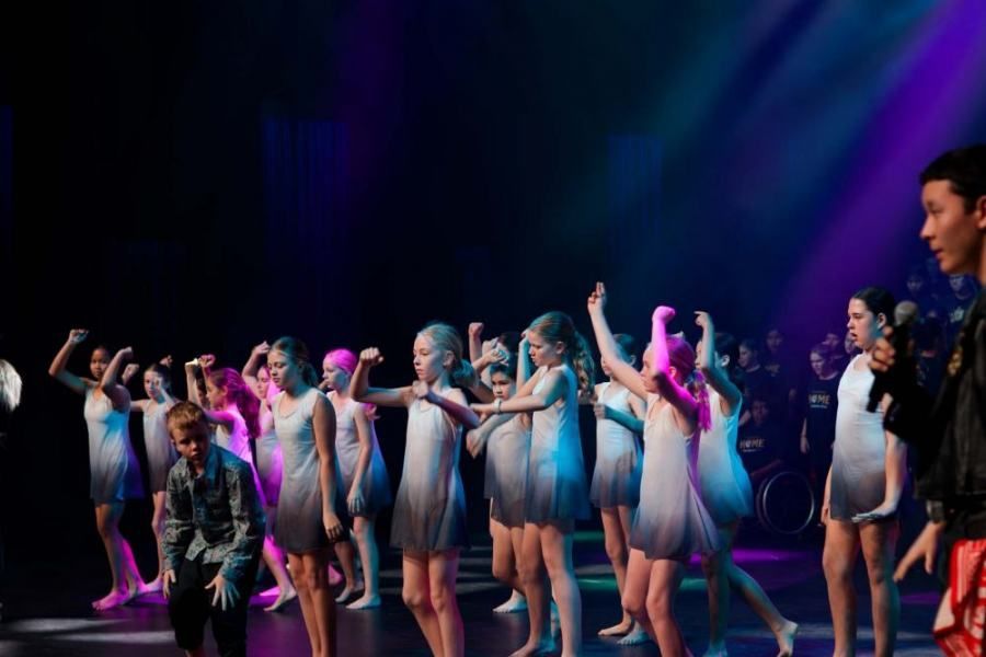 A group of young girls are dancing on a stage.