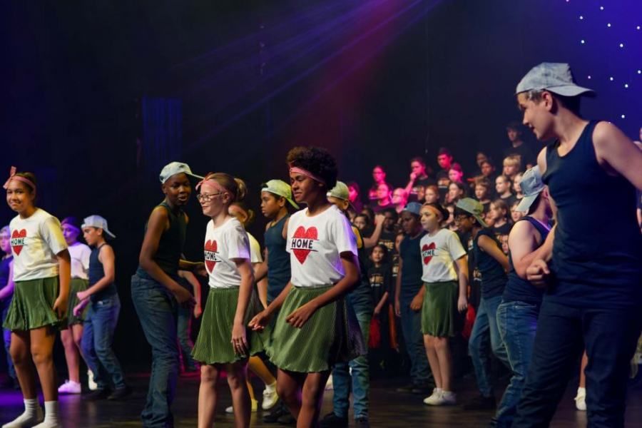 A group of children are dancing on a stage.