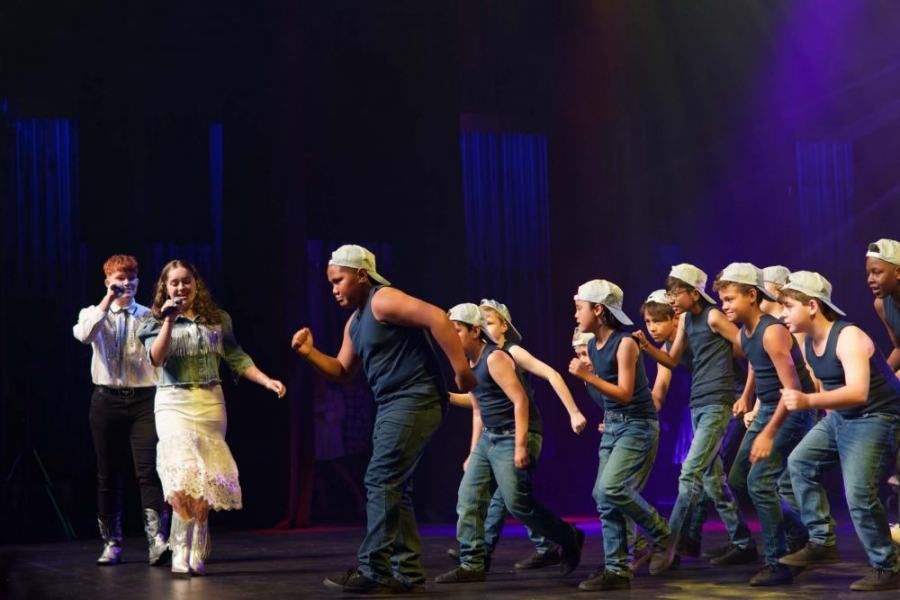 A group of young people are dancing on a stage.