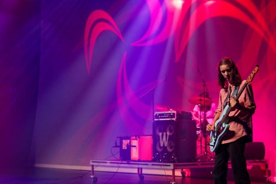 A man is playing a guitar on a stage.