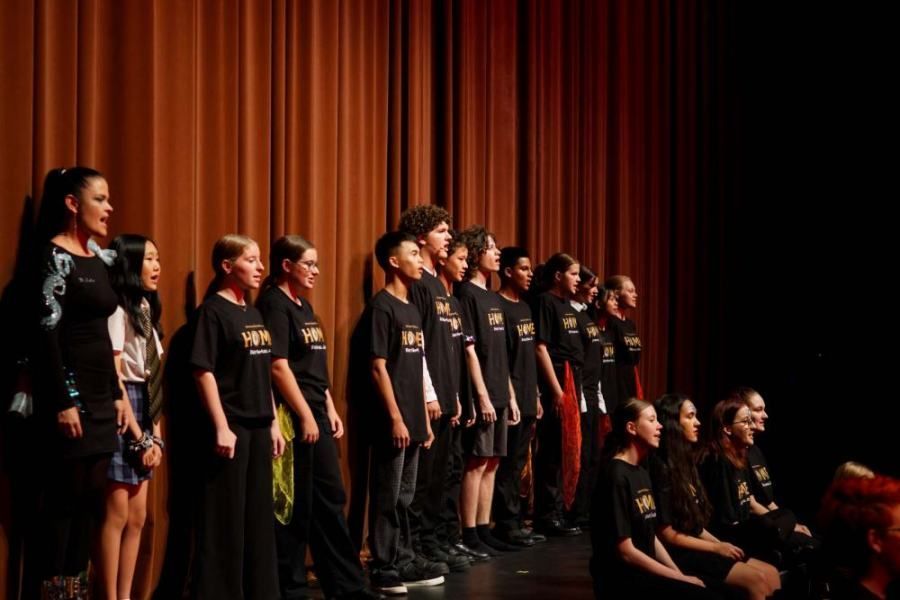A group of children are singing on a stage.