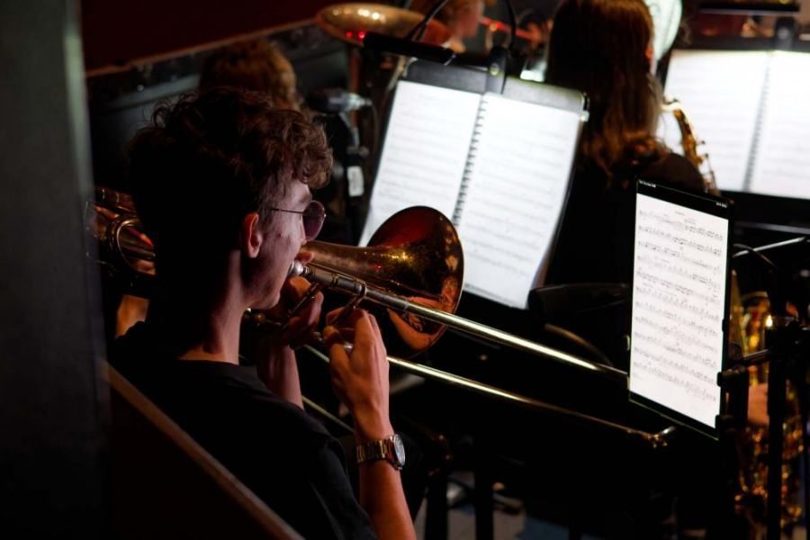 A man is playing a trombone in an orchestra.