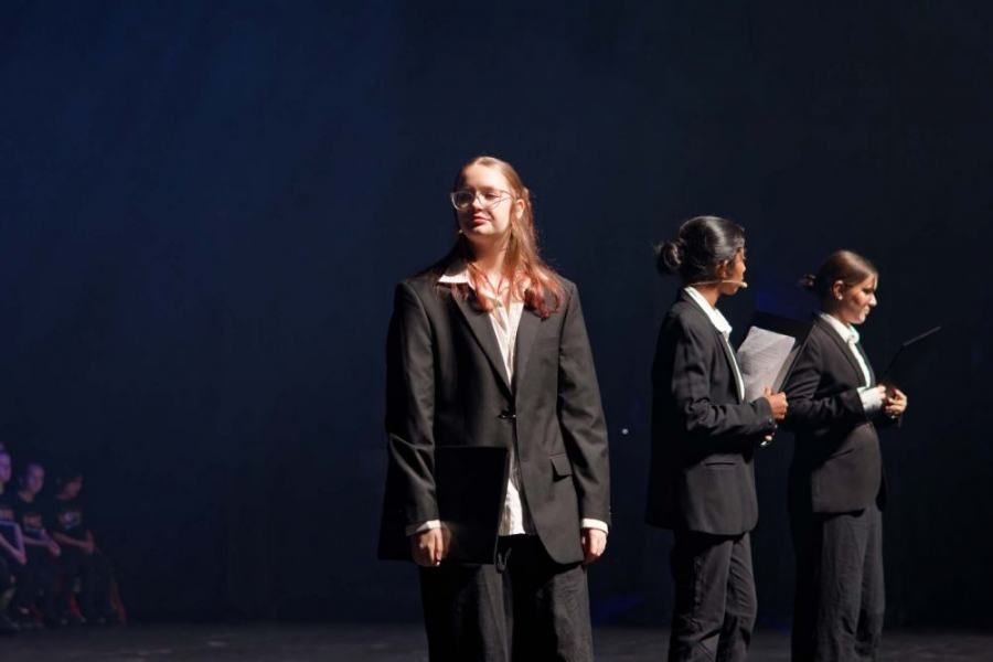 A group of people in suits are standing on a stage.
