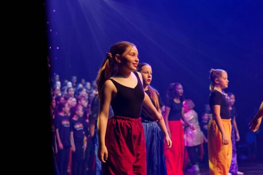 A group of young girls are dancing on a stage.