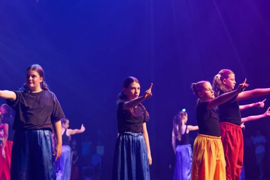 A group of young girls are dancing on a stage.