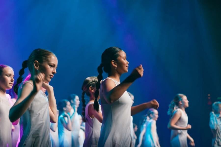 A group of young girls are dancing on a stage.