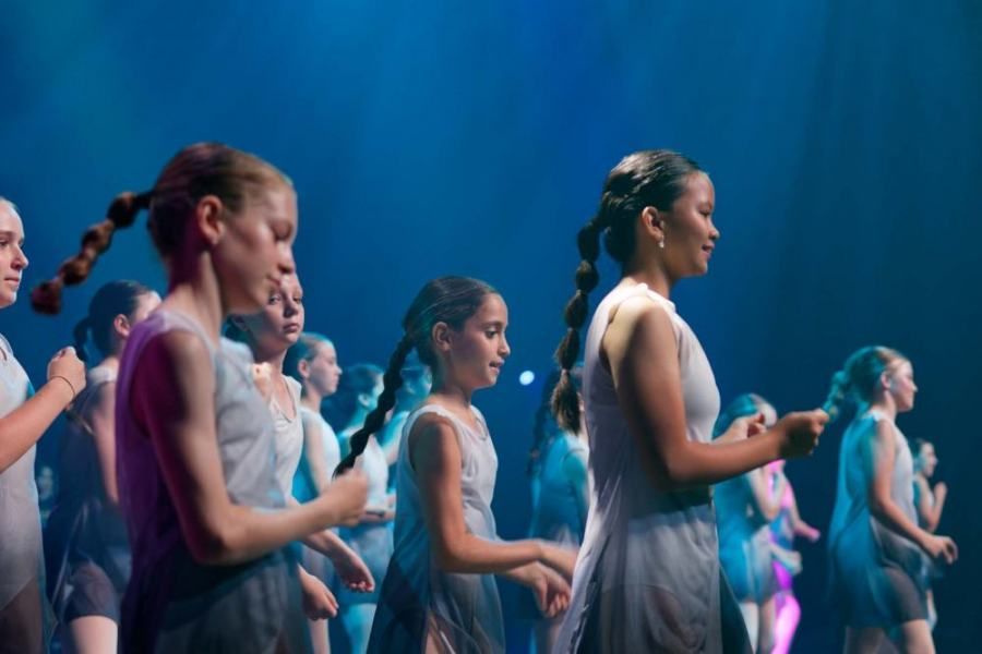 A group of young girls are dancing on a stage.