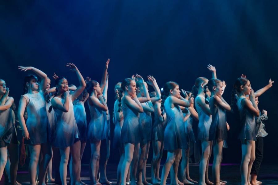 A group of young girls are dancing on a stage.