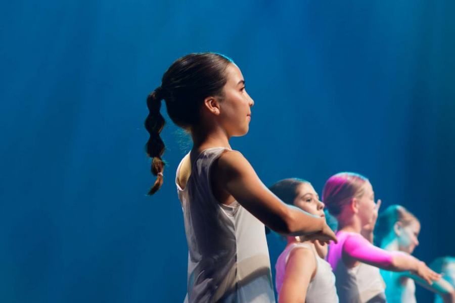A group of young girls are dancing on a stage.