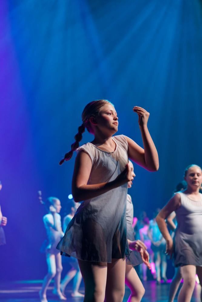 A group of young girls are dancing on a stage.
