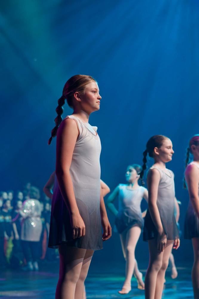 A group of young girls are standing on a stage.