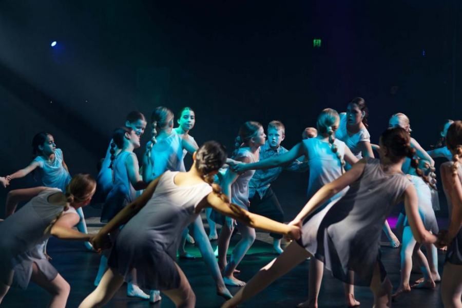 A group of dancers are dancing together on a stage.