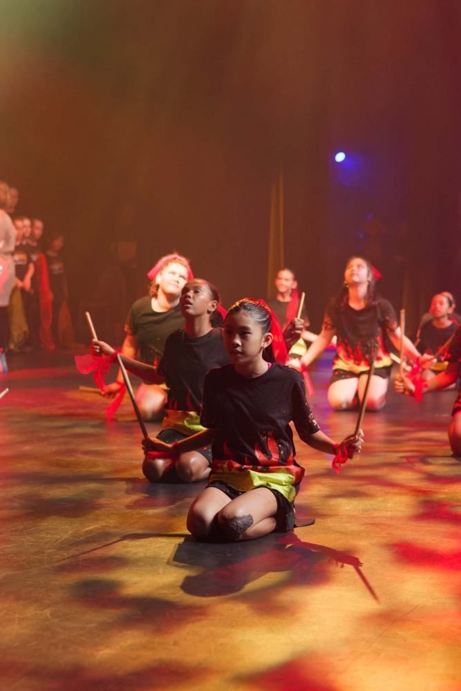 Children playing drums at a performance