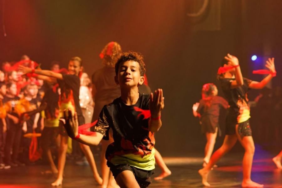 A group of young people are dancing on a stage.