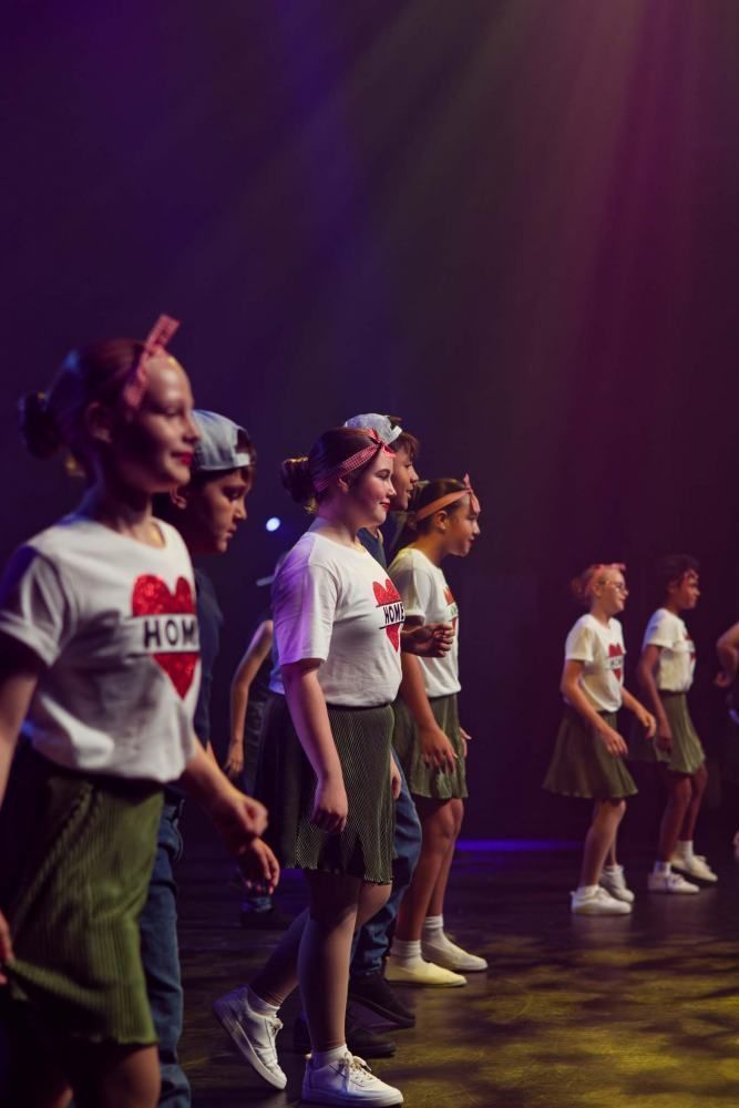 A group of young people are dancing on a stage.