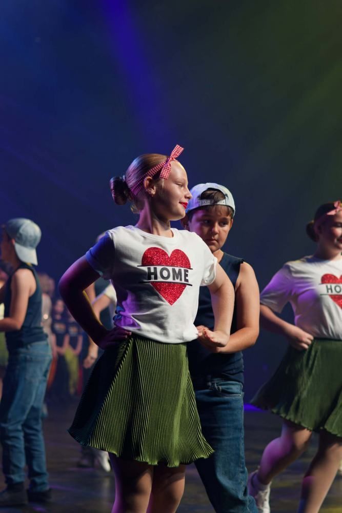 A group of children are dancing on a stage.