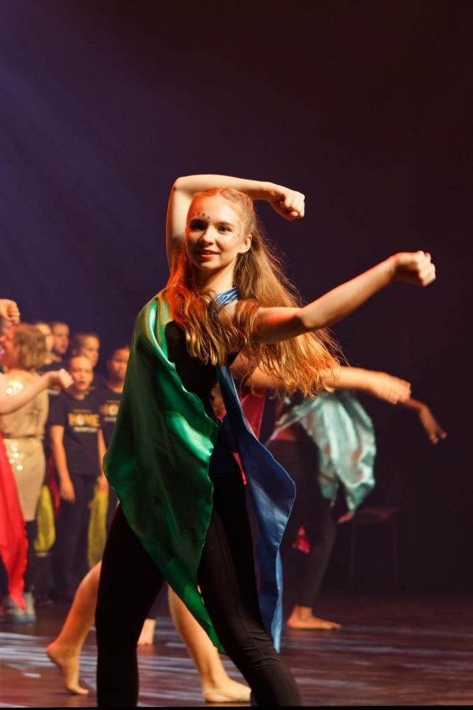 A group of young girls are dancing on a stage.