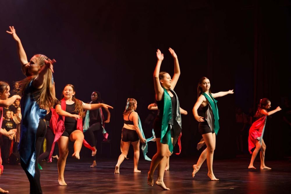 A group of young girls are dancing on a stage.