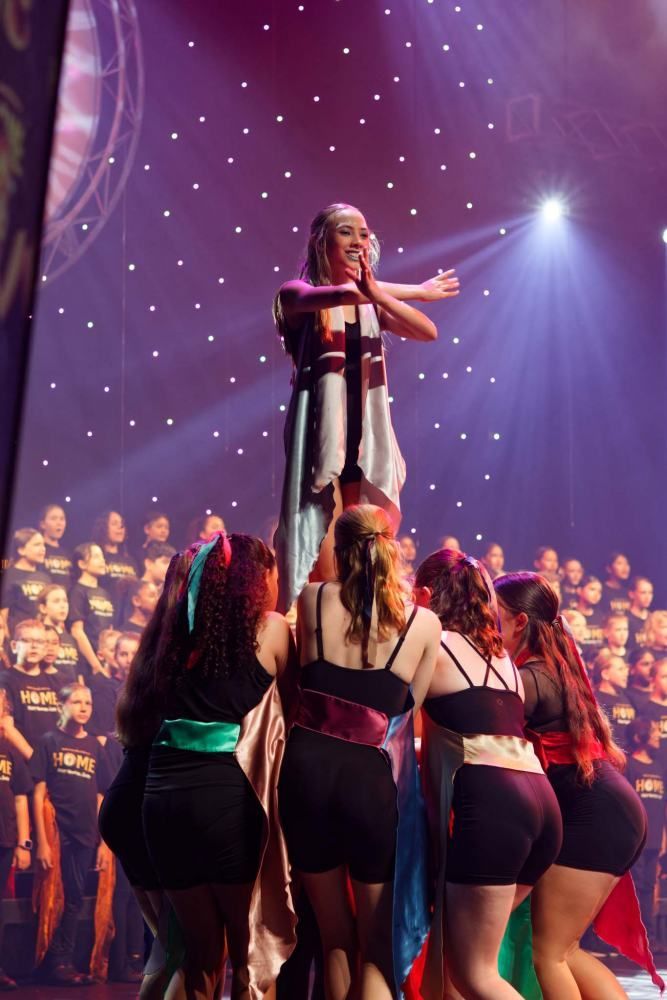 A group of women are standing on top of each other on a stage.