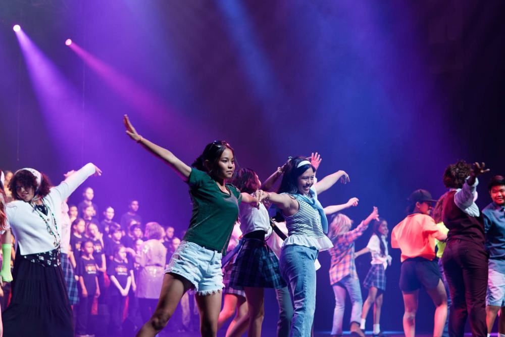 A group of young people are dancing on a stage.