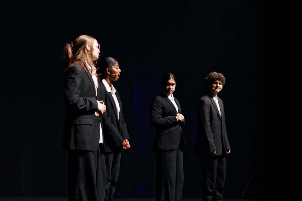 A group of people in suits are standing on a stage.