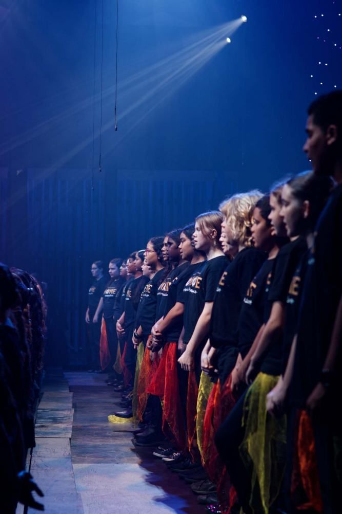 A group of people are standing in a row on a stage