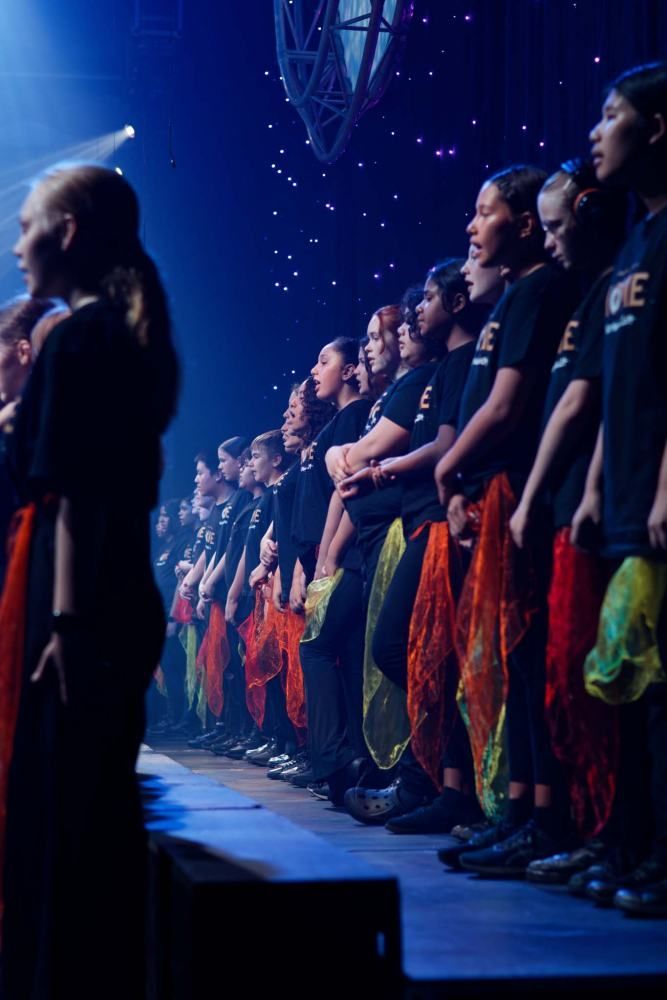 A group of people are standing in a row on a stage.