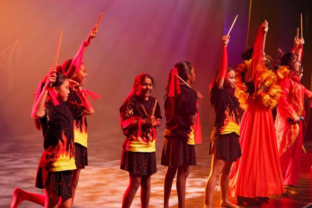 A group of young girls are dancing on a stage.