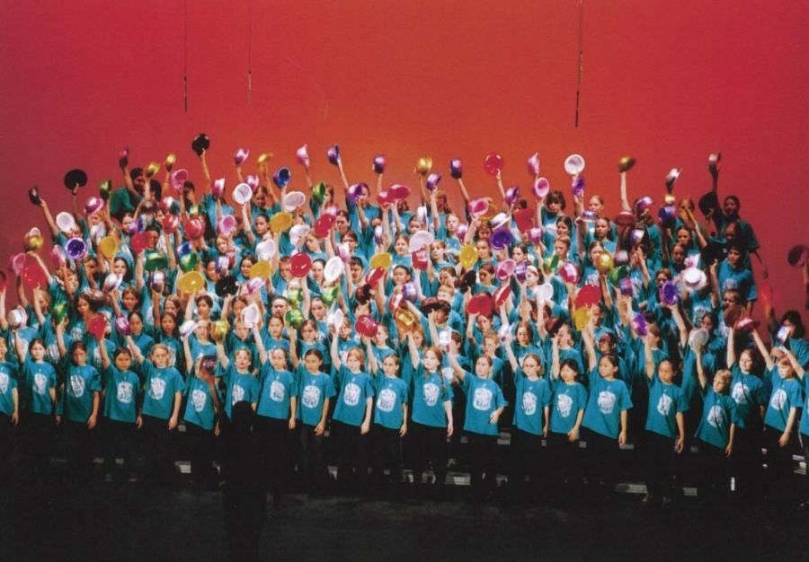 A large group of people standing on a stage with their arms in the air