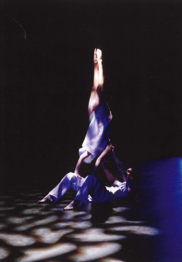 A couple of people are dancing in a dark room