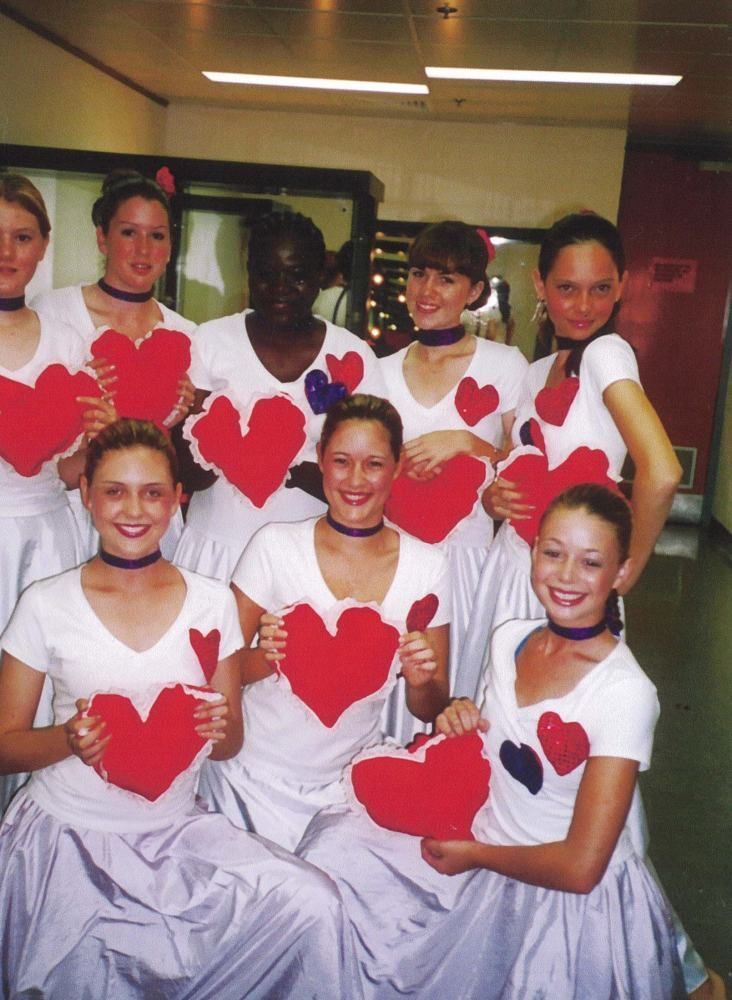 A group of women holding red hearts in their hands