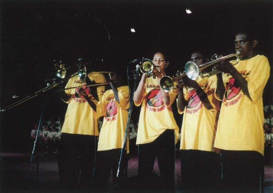 A group of people in yellow shirts are playing instruments